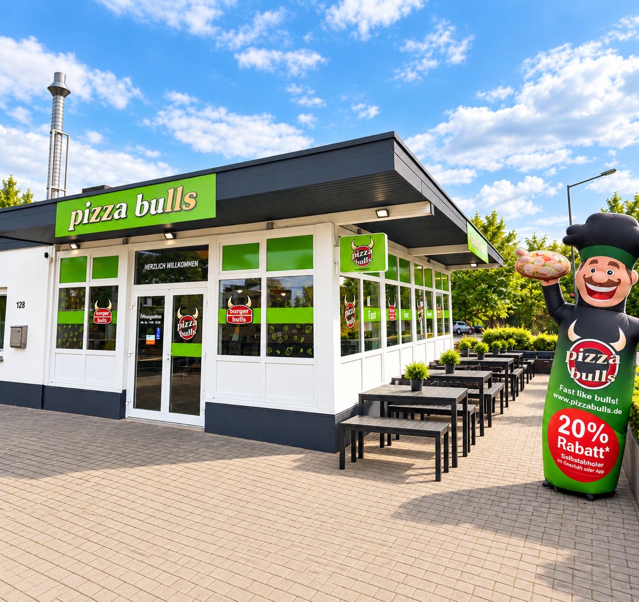Burger Bulls Filiale bei Tag mit großem pizza bulls Schriftzug, Außensitzplätzen und Pizza-Bulls-Figur mit Pizza